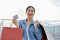Adorable Asian woman holding credit card and carrying shopping bags Royalty Free Stock Photo