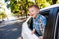 Adorable baby boy in the car. Laughing boy looks out of the car window. Royalty Free Stock Photo