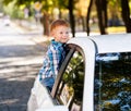 Adorable baby boy in the car. Laughing boy looks out of the car window. Royalty Free Stock Photo