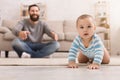 Adorable baby boy crawling on floor with dad Royalty Free Stock Photo