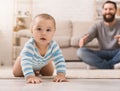 Adorable baby boy crawling on floor with dad Royalty Free Stock Photo