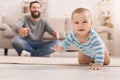 Adorable baby boy crawling on floor with dad Royalty Free Stock Photo