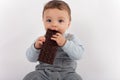 Adorable baby boy eating a plate of chocolate. Royalty Free Stock Photo