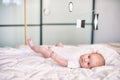 Adorable baby boy in white sunny bedroom lying and looks at Munari Montessori mobile. Royalty Free Stock Photo
