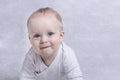 Adorable baby boy learning to crawl and playing. Cute laughing child crawling on a bed. Copy space. Royalty Free Stock Photo