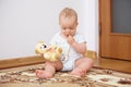 Adorable baby boy playing with plush toy in badroom