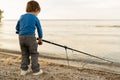 Adorable baby boy on river with fishing-rod and fishing. little child fishing on lake