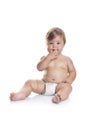 Adorable baby boy sitting with fingers in his mouth Royalty Free Stock Photo