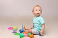 Adorable baby boy sitting on the floor and playing with his toys. Royalty Free Stock Photo