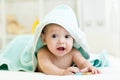 Adorable baby boy under a hooded towel after