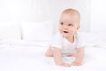 Adorable baby boy in white sunny bedroom