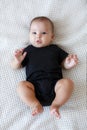 Cute baby lies and crawls on a white bed in a bright bedroom alone. Royalty Free Stock Photo