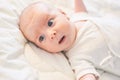 Adorable baby boy in white sunny bedroom. Newborn infant child relaxing in bed. Royalty Free Stock Photo