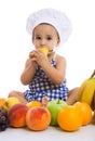 Adorable baby chef eating fruits Royalty Free Stock Photo