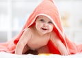 Adorable baby child under a hooded towel after