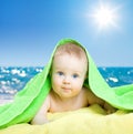 Adorable baby in colorful towel on sea beach Royalty Free Stock Photo