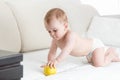 Adorable baby crawling on bed and reaching for apple Royalty Free Stock Photo