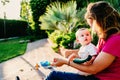 Adorable baby with curious face looking at his enraptured mother