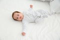 Adorable baby in cute footie on white sheet