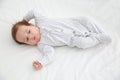 Adorable baby in cute footie on white sheet