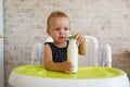 Adorable baby drinking milk from a bottle from bottle. Formula drink for infant. Kitchen Royalty Free Stock Photo