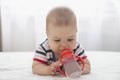 Adorable baby drinking water lying on the bed Royalty Free Stock Photo