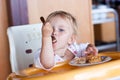 Adorable baby eating cake in a chair