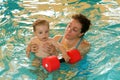 Adorable baby enjoying swimming in a pool with his mother Royalty Free Stock Photo