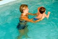 Adorable baby enjoying swimming in a pool with his mother Royalty Free Stock Photo