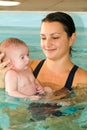 Adorable baby enjoying swimming in a pool with his mother Royalty Free Stock Photo