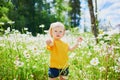 Adorable baby girl amidst green grass and beauitiful daisies