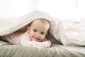 Adorable baby girl cover with white sheet wearing pink clothes Royalty Free Stock Photo