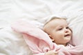 Adorable baby girl cover with white sheet wearing pink clothes Royalty Free Stock Photo