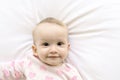 Adorable baby girl cover with white sheet wearing pink clothes Royalty Free Stock Photo