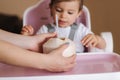 Adorable baby girl drink coconut in high chair. Cute little girl first time taste exotic fruit Royalty Free Stock Photo