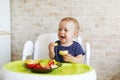 Adorable baby girl eating fresh vegetables and cheese; healthy eating for a baby Royalty Free Stock Photo