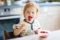 Adorable baby girl eating from spoon fresh healthy raspberries food, child, feeding and development concept. Cute Royalty Free Stock Photo