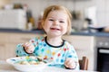 Adorable baby girl eating from spoon vegetable noodle soup. food, child, feeding and development concept. Cute toddler Royalty Free Stock Photo