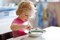 Adorable baby girl eating from spoon vegetable noodle soup. food, child, feeding and development concept. Cute toddler Royalty Free Stock Photo