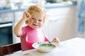 Adorable baby girl eating from spoon vegetable noodle soup. food, child, feeding and development concept. Cute toddler Royalty Free Stock Photo