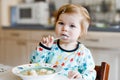 Adorable baby girl eating from spoon vegetable noodle soup. food, child, feeding and development concept. Cute toddler Royalty Free Stock Photo