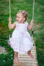 Adorable baby girl enjoying a swing ride on a playground in a park Royalty Free Stock Photo