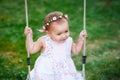 Adorable baby girl enjoying a swing ride on a playground in a park Royalty Free Stock Photo