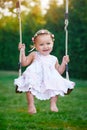 Adorable baby girl enjoying a swing ride on a playground in a park Royalty Free Stock Photo