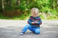 Adorable baby girl in the forest, sitting on the ground Royalty Free Stock Photo