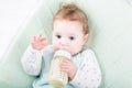 Adorable baby girl on a green blanket drinking milk Royalty Free Stock Photo