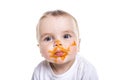 Adorable baby girl making a mess while feeding