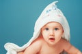 Adorable baby girl. Newborn child relaxing and laying on belly on bed with white towel on head. Nursery for young children. Textil Royalty Free Stock Photo