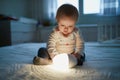 Adorable baby girl playing with bedside lamp in nursery Royalty Free Stock Photo