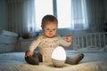 Adorable baby girl playing with bedside lamp in nursery Royalty Free Stock Photo